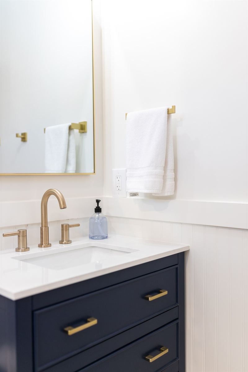 Main House Bottom Unit En-Suite Bathroom #1 with floor to ceiling porcelain tile, walk-in shower with oversized rainfall shower head and handheld shower feature, large in-shower window and vanity,