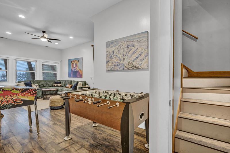 Downstairs game room with cozy large sofa, infinity game, fooseball and suffleboard tables, pinball machine and a cozy nook for the little ones.