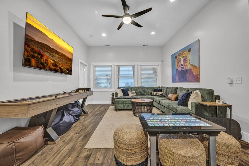 Downstairs game room with cozy large sofa, infinity game, fooseball and suffleboard tables, pinball machine and a cozy nook for the little ones.