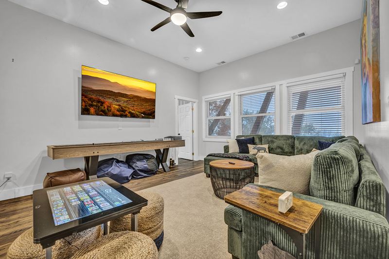 Downstairs game room with cozy large sofa, infinity game, fooseball and suffleboard tables, pinball machine and a cozy nook for the little ones.