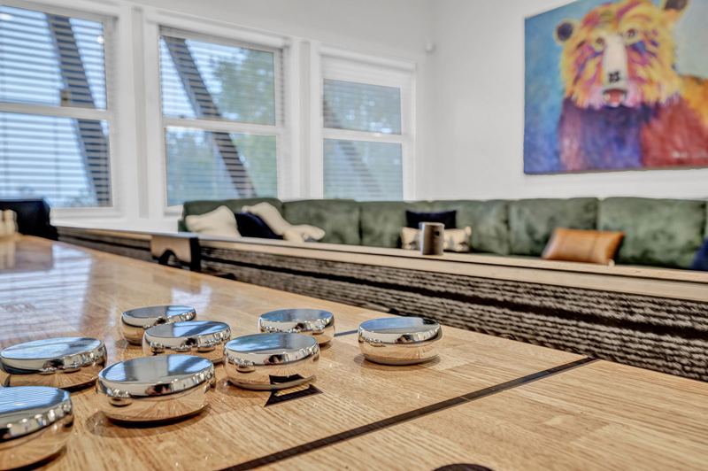 Downstairs game room with cozy large sofa, infinity game, fooseball and suffleboard tables, pinball machine and a cozy nook for the little ones.