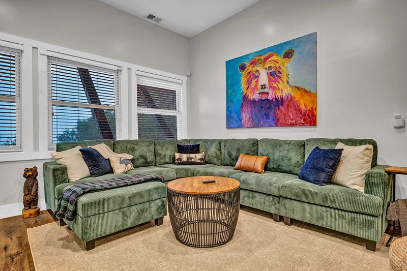 Downstairs game room with cozy large sofa, infinity game, fooseball and suffleboard tables, pinball machine and a cozy nook for the little ones.