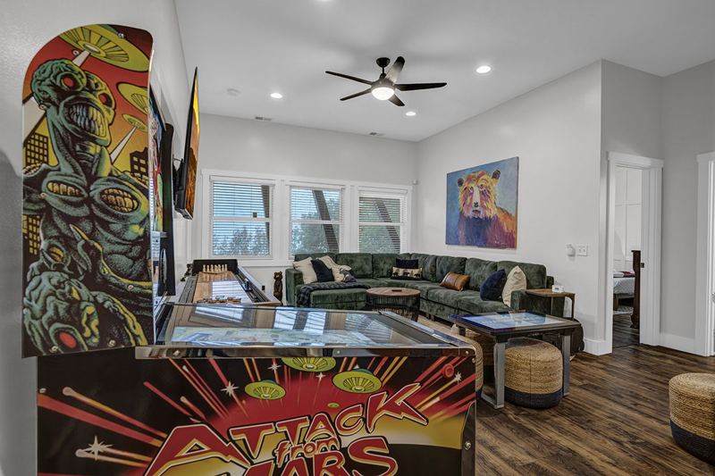 Downstairs game room with cozy large sofa, infinity game, fooseball and suffleboard tables, pinball machine and a cozy nook for the little ones.