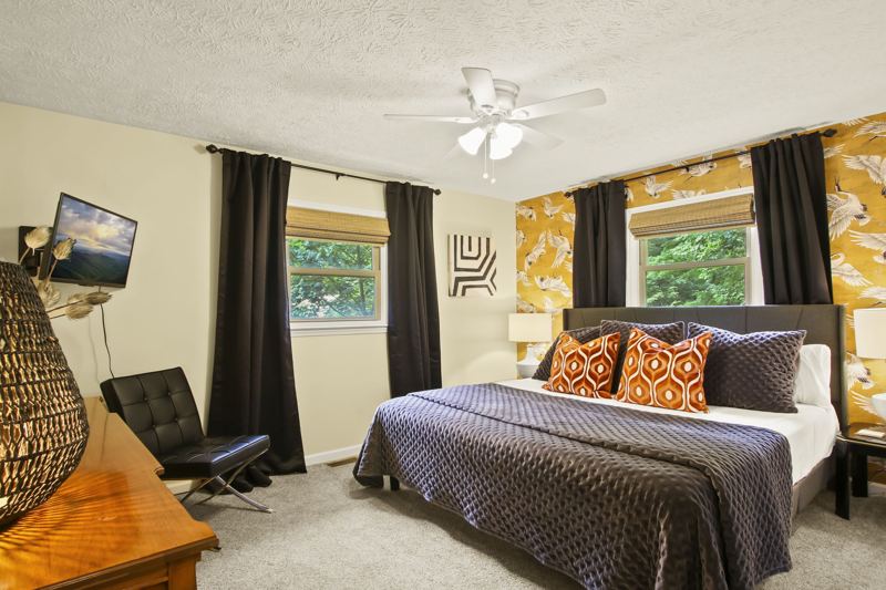 Main Level Bedroom (Summer Room) with King Bed, 43-inch Smart TV, large dresser and spacious closet, blackout curtains, white noise machine and luggage rack.  Additional Cot in closet.