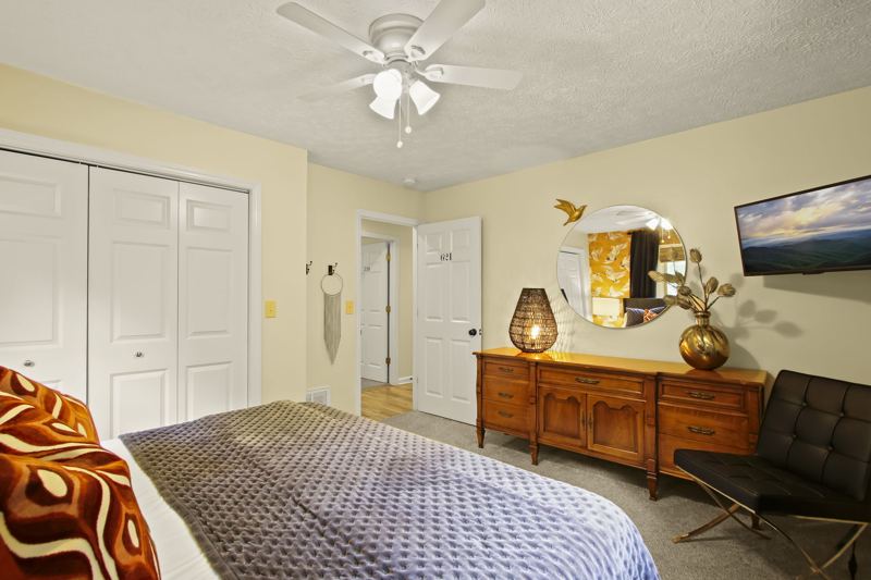 Main Level Bedroom (Summer Room) with King Bed, 43-inch Smart TV, large dresser and spacious closet, blackout curtains, white noise machine and luggage rack.  Additional Cot in closet.