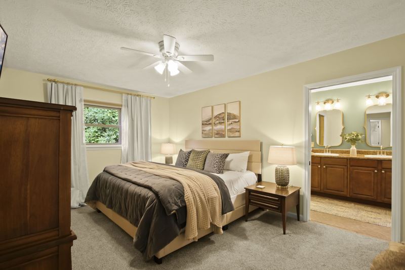 Main Level Bedroom (Spring Room) with King Bed, En-suite full bathroom with dual vanity, 43-inch Smart TV, workstation, large dresser, blackout curtains, white noise machine and luggage rack.