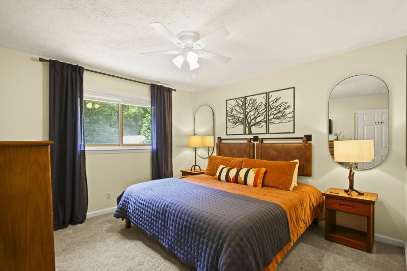 Main Level Bedroom (Fall Room) with King Bed, 43-inch Smart TV, large dresser, room darkening curtains, white noise machine and luggage rack.