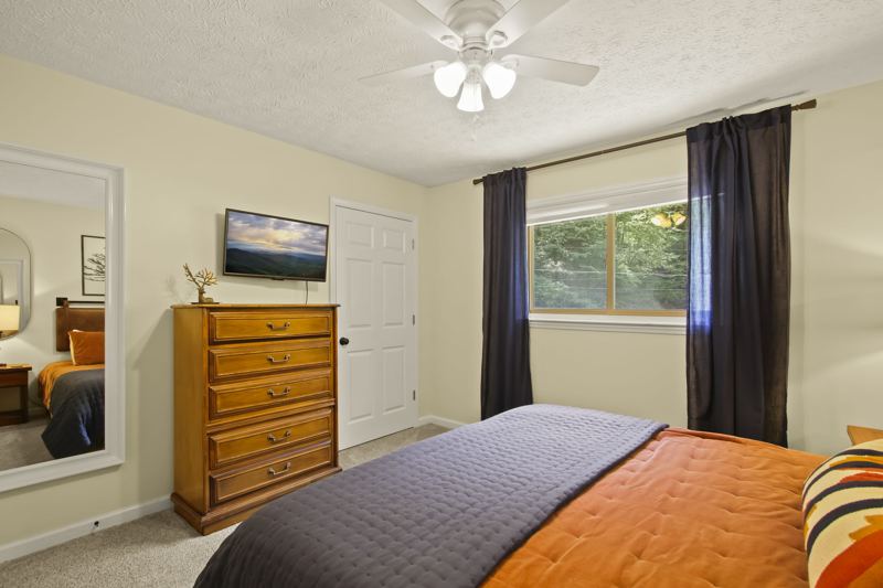 Main Level Bedroom (Fall Room) with King Bed, 43-inch Smart TV, large dresser, room darkening curtains, white noise machine and luggage rack.