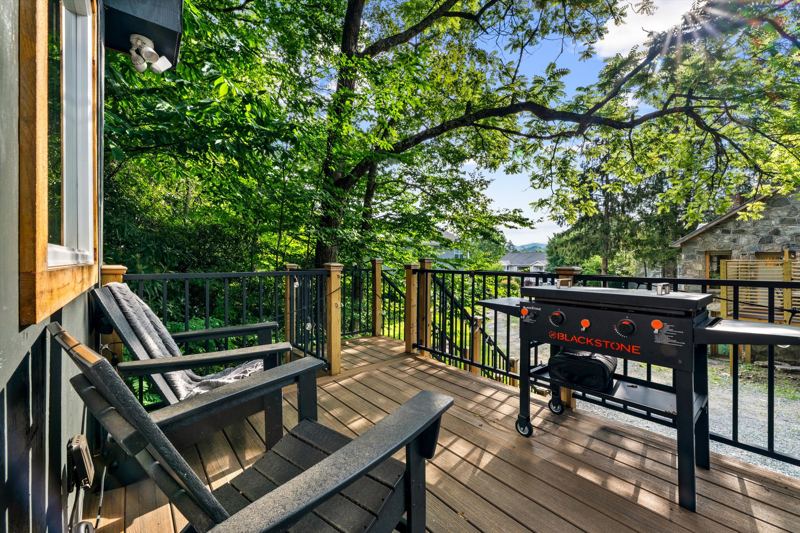 Deck with Blackstone Grill, cafe lights, bistro table and sitting chairs