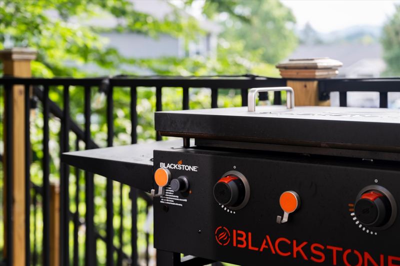 Deck with Blackstone Grill, cafe lights, bistro table and sitting chairs