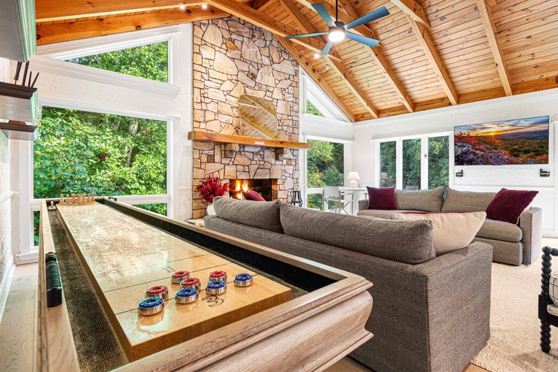 East Great Room with gas fireplace, 65-inch Smart TV, Shuffleboard Table and views of the Waterfall!