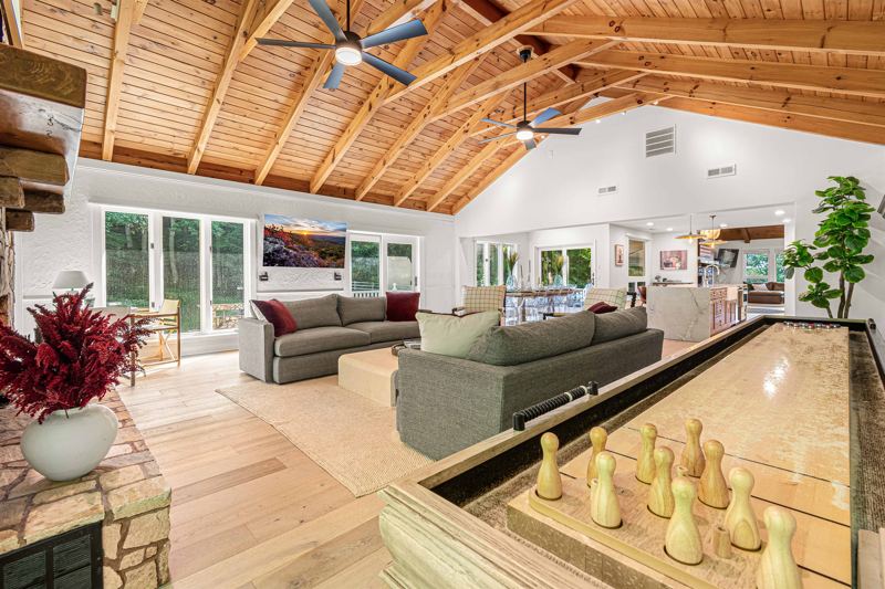 East Great Room with gas fireplace, 65-inch Smart TV, Shuffleboard Table and views of the Waterfall!
