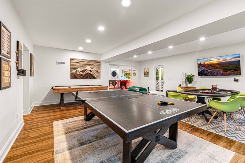 Entire Lower Level is the Game Room - complete with 8-Person Poker Table, Air Hockey, Ping Pong, Foosball, Bubble Hockey, 5,000+ Game Arcade Machine, 55-inch TV, and retractable sliding doors to still be one with nature.
