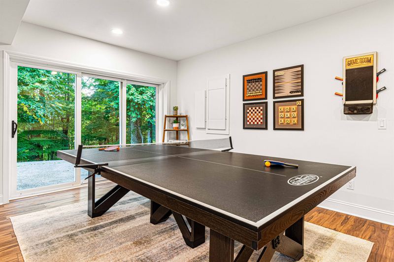 Entire Lower Level is the Game Room - complete with 8-Person Poker Table, Air Hockey, Ping Pong, Foosball, Bubble Hockey, 5,000+ Game Arcade Machine, 55-inch TV, and retractable sliding doors to still be one with nature.