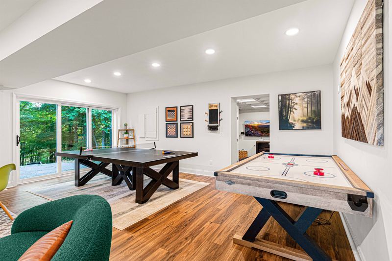 Entire Lower Level is the Game Room - complete with 8-Person Poker Table, Air Hockey, Ping Pong, Foosball, Bubble Hockey, 5,000+ Game Arcade Machine, 55-inch TV, and retractable sliding doors to still be one with nature.