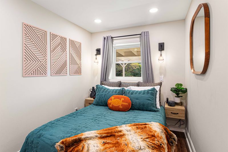 Lower-Level Bedroom with Queen Bed, En-Suite Full Bathroom with floor to ceiling porcelain tile walk-in shower, oversized rainfall shower head and handheld feature, large in-shower window and