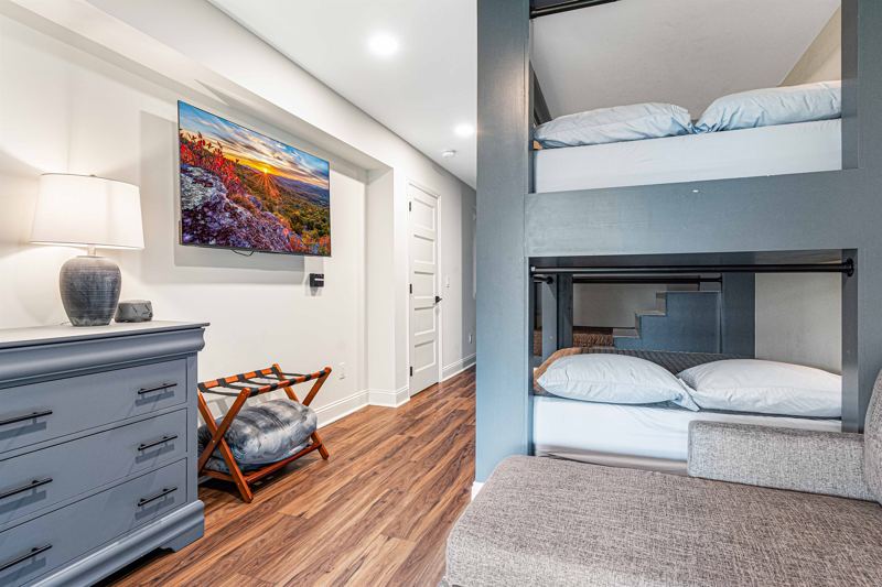Lower- Level Queen Built-In Bunk Room with 55-inch Smart TV, Individual Reading lights by each bed and Dresser