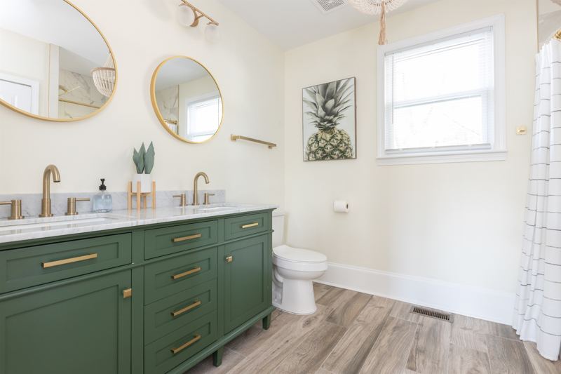 Bottom Floor En-Suite Bathroom #2 with oversized rainfall shower head and handheld shower features, tub and double vanity.