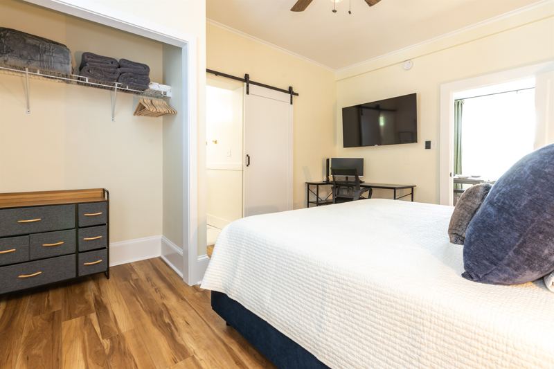 Main House Bottom Unit Bedroom #1 with King Bed, En-Suite Bathroom, Workstation with desk, lamp and monitor, 55-inch adjustable ROKU TV, Sound Machine & Blackout Curtains.