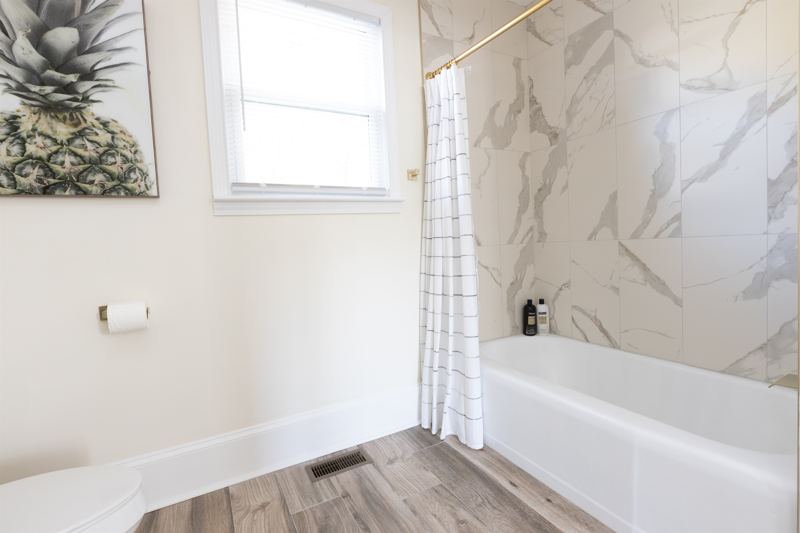 Main House Bottom Floor Unit En-Suite Bathroom #2 with oversized rainfall shower head & handheld shower feature, tub and double vanity.